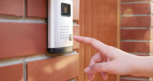 Hand about to ring a doorbell