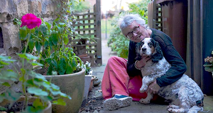 smiling lady in the garden with her dog