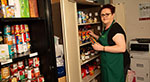 Food bank worker with food cupboards