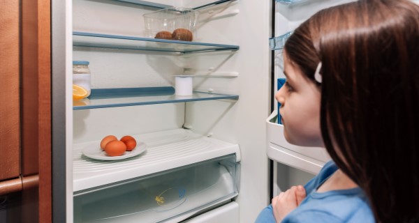 Young girl looking into an empty fridge