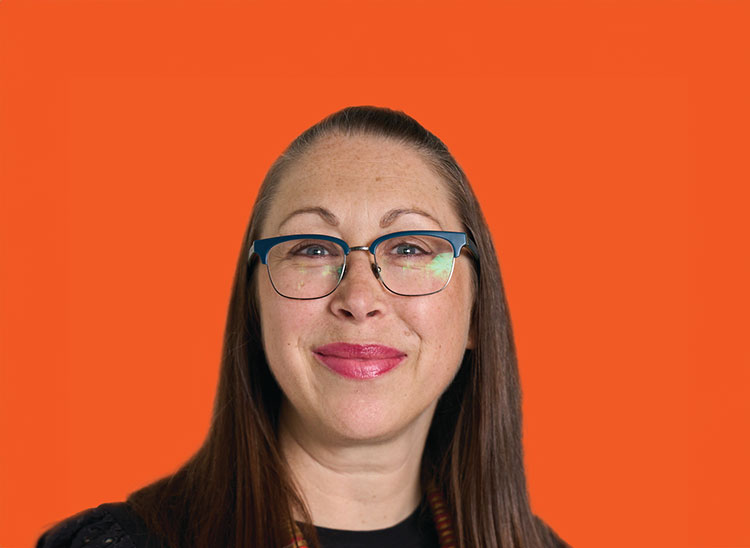 Sarah McLoughlin - long dark hair, smiling and wearing glasses