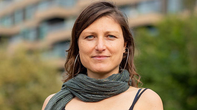 Smiling woman with brown hair standing in garden