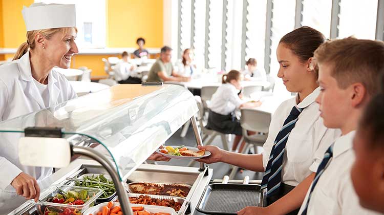 Children queuing up for school meals in a canteen