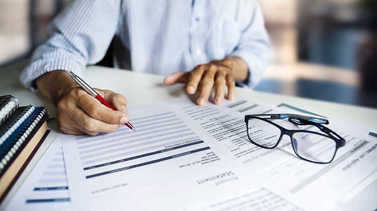 Man revising his paper accounts at desk