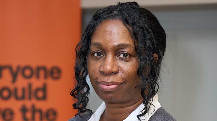 Joyce Frederick wearing white shirt and grey jumper