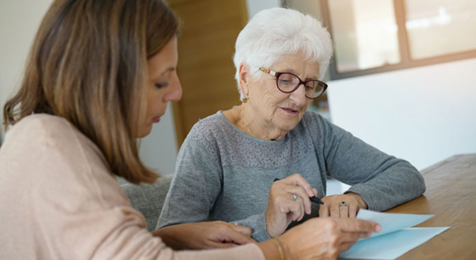 Younger woman reviewing paperwork with older woman