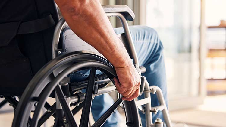 Man with hands on the wheels of his wheelchair
