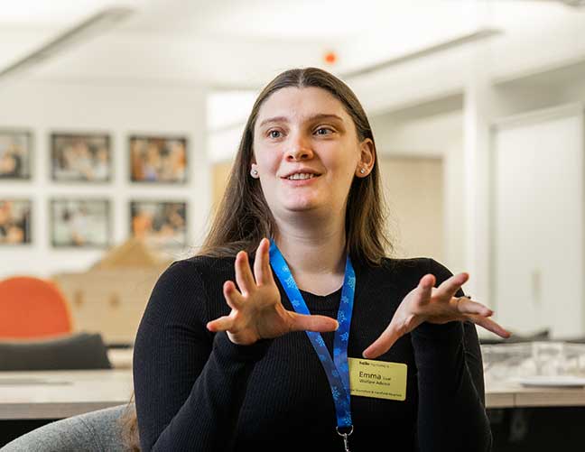 Woman wearing black top talking in Turn2us office