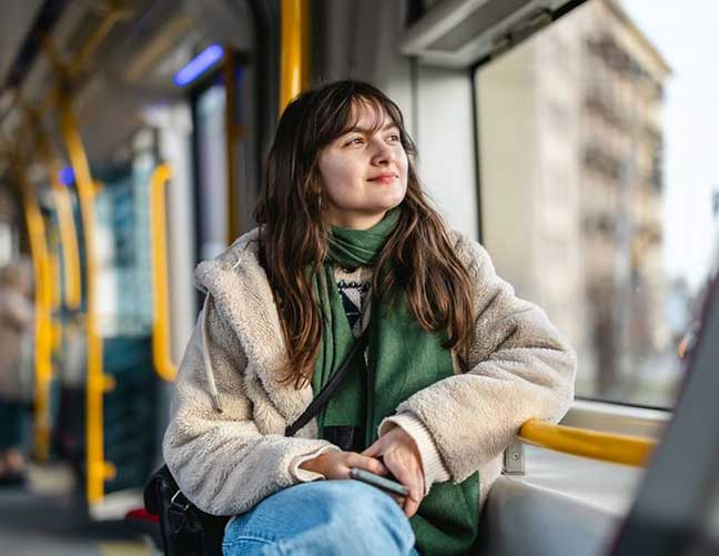 Woman with long dark hair looking out of a train window