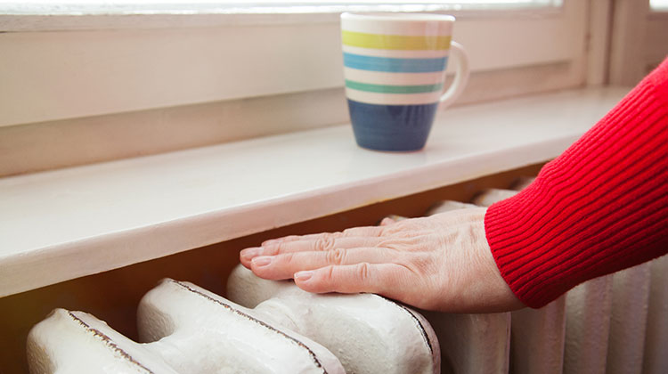 Person holding hand over radiator