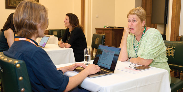 Female MP with short hair sits at a table talking to a jobcentre adviser at our Jobcentre event