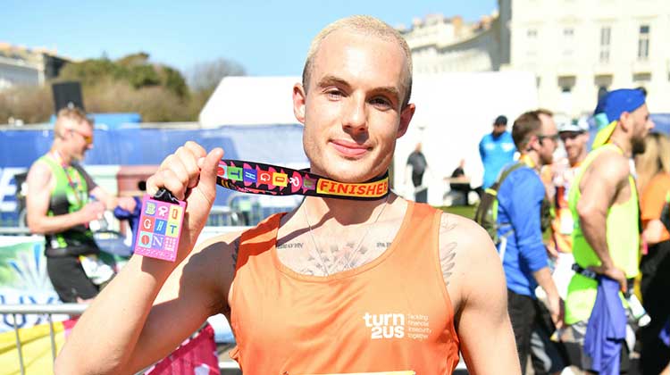 Turn2us runner with medal at end of Brighton marathon