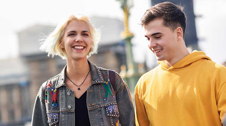 Teenage girl and boy in conversation and smiling