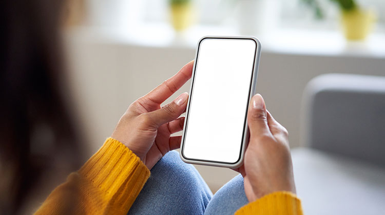 Woman wearing yellow jumper and using mobile